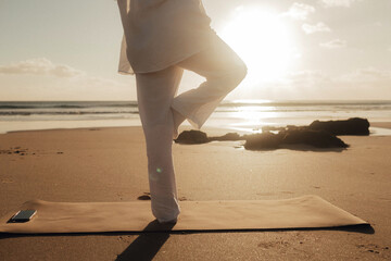Asian woman in white clothes practice yoga for meditation and relaxation for healthy near seaside....
