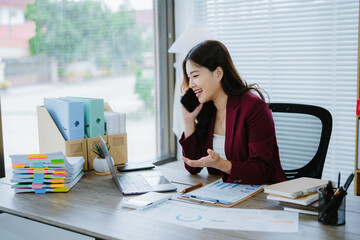 Modern Office Worker: A focused businesswoman diligently works at her desk in a bright, modern...