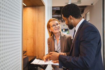 Two multicultural businesspeople talk while scan document on a scanner