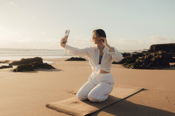 Young girl recording video on phone share via app her travel vacation near seaside. Gen Z...