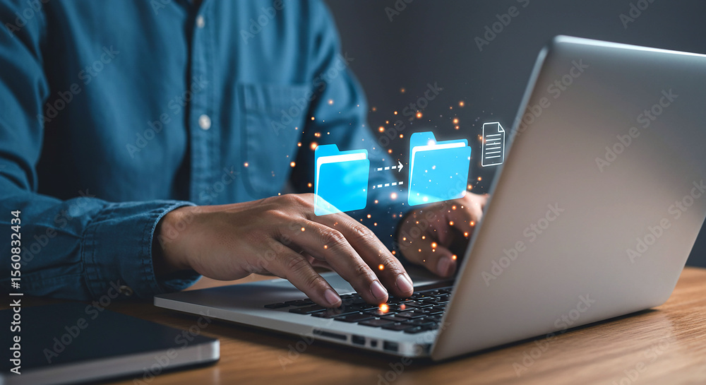 Poster man using laptop with folder transfer graphic overlay on the screen and wooden desk surface view