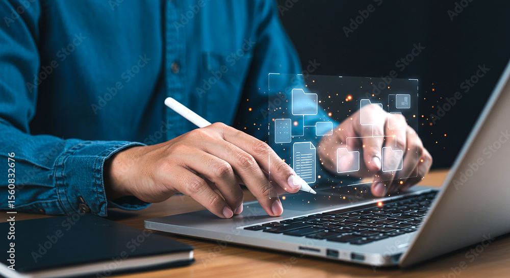 Poster person using stylus on laptop with digital folder icons overlayed on the screen in dark setting