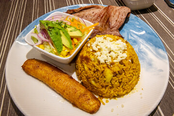 Recipe for Moro rice with beef steak, fried plantain, and salad on a porcelain plate