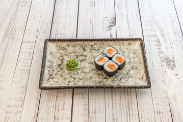 makisu, the end of the nori closest to the cook is lifted and rolled tightly over the filling, applying even pressure to create a compact cylinder.