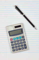 Calculator and pen on a white sheet of paper background.