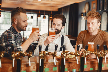 Three men in shirts in the bar.