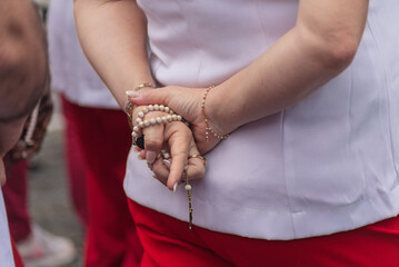 Details of hands of religious person holding crucifix.