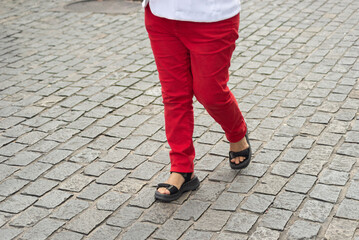 Half-body of people walking on the street wearing red clothes. Religious procession.