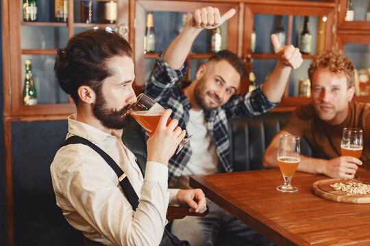 Three men in shirts in the bar.