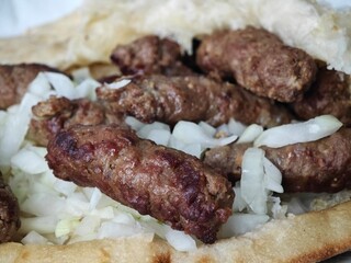 Grilled kebabs served in pita bread with chopped onions and fresh herbs at a local eatery in the...