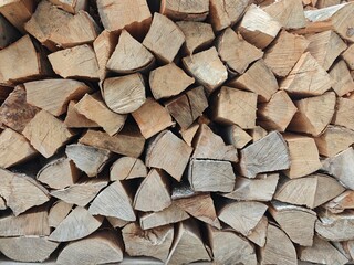 Stacked firewood ready for cooking and warmth in a cozy cabin during winter months in a rustic...