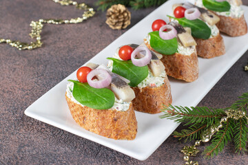 Bruschetta with herring, cream cheese, spinach and cherry tomatoes