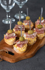 Canape with bacon, egg and green olives