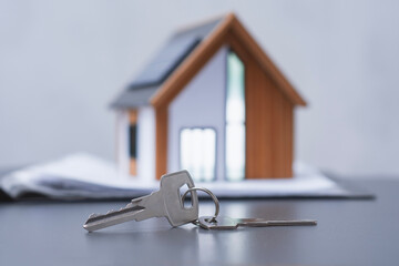 House keys with a model of a modern house with solar panels on the roof. Concept eco-friendly housing and energy efficiency.