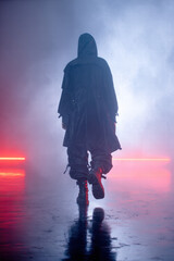 Back view of a faceless model walking into fog in techwear duster coat, wide tactical pants, 