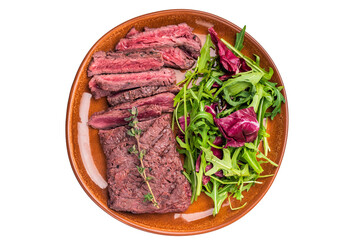 Grilled Skirt machete beef steak, roasted sliced meat on plate with salad isolated on white background. top view