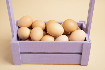 Brown eggs in lavender wooden crate – front view