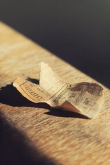 Torn vintage movie ticket stub on textured wooden table with warm natural light and soft shadows, faded colors and nostalgic sentimental mood Generative AI