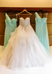 Elegant wedding dresses hang on display in a bridal suite before a joyful wedding ceremony