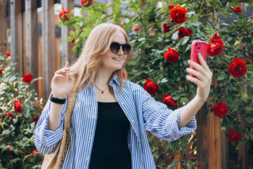 Young Caucasian blonde 30s woman smiling confident making selfie by the smartphone at park