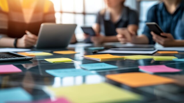 Collaborative business meeting with diverse professionals engaging over creative ideas at a glass table filled with colorful sticky notes and digital devices, overtheshoulder angle evokes teamwork an.