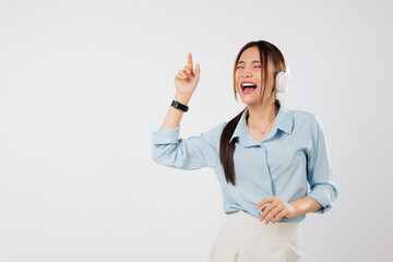 Music flows as happy young Asian woman raises hands dancing with headphones, while her lifestyle is filled with joy, smile, People emotions, and uplifting music. isolated studio white background