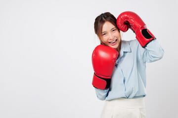 Boxing style meets business attitude in this strong smiling Asian young woman. Fitness, guard pose, and ready-to-fight spirit define her red boxing power. isolated studio white background