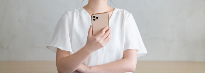 スマホを見て悩む女性