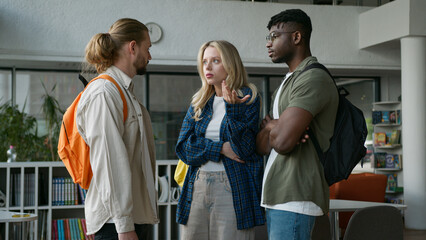 Obraz premium Group of diverse college friends three multiracial students meeting in university hall upset Caucasian woman girl frustrated African American men guys support calming talking multicultural friendship