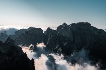 Afternoon summer view of Pico do Arieiro mountain with clouds cutting across the base, clear sky...