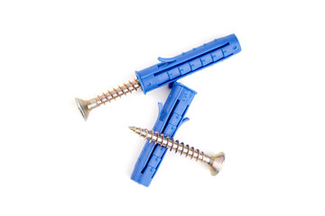 Blue plastic wall anchors with screws arranged in a creative layout on a white background,...