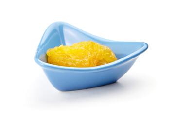 Dehydrated yellow pears in a blue triangular bowl, showcasing their unique texture and color, perfect for artistic or culinary presentations and creative projects