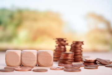 Arranged wooden blocks and coins suggesting financial planning, savings, and sustainable investment...