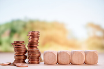 Coins arranged beside wooden blocks indicating financial planning, growth, and investment with...