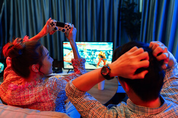 Couple gamer with joystick playing fighting competition video game, woman winner player challenge...