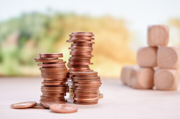 Stacked coins and wooden blocks representing financial planning, investment, and savings with...