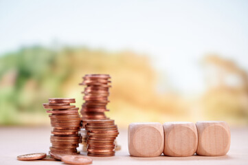 Coins and wooden blocks stacked showing financial planning, growth, and investment with blurred...