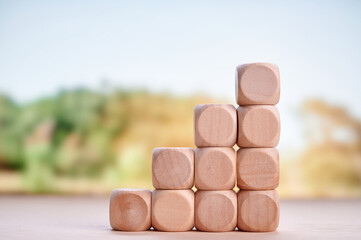 Wooden blocks stacked to form pyramid highlighting investment, financial planning, and growth with...
