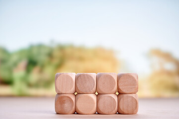 Pile of wooden blocks showing investment, financial planning, and growth with blurred nature-inspired background emphasizing sustainable and eco-friendly business themes