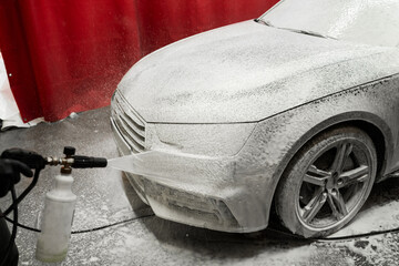 Car gets covered in thick snow foam during initial washing phase for deep dirt removal. Car Foaming...
