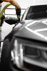Exterior Car Drying with Compressed Air. High-pressure air is directed at tight vehicle seams to...