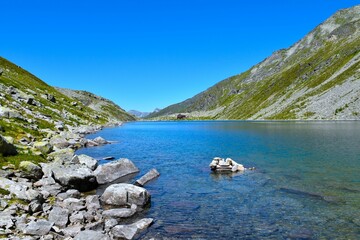 Rocks at the shore of blue colored Dösner lake in High Tauern, Carinthia, Austria