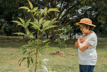 Senior woman expressing gratitude for new trees in park