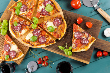 Pizza slices with sausage on a wooden board