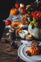 Fall table decoration with pumpkins, wine. Family cozy thanksgiving dinner arrangement indoors at...