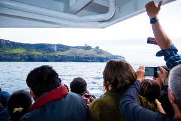 Tourists on a boat crowding to get pictures of the Cliffs of Mor near Galway on a Ferry Boat