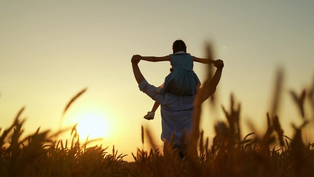 Child dad dream together in nature. Family dad child with child on shoulders running through wheat field. Parent dad girl child run together. Kid daughter father playing enjoying outdoors dream fly