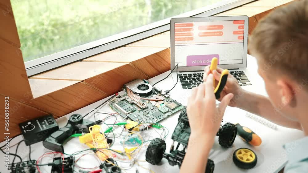 Poster top view of happy student study car model construction at table with electronic equipment and laptop