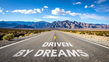 Open road featuring an inspiring message in the desert against a backdrop of mountains and bright blue sky during the day