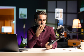 Media star presenting mobile phone from brand sponsoring video, urging subscribers to purchase it....